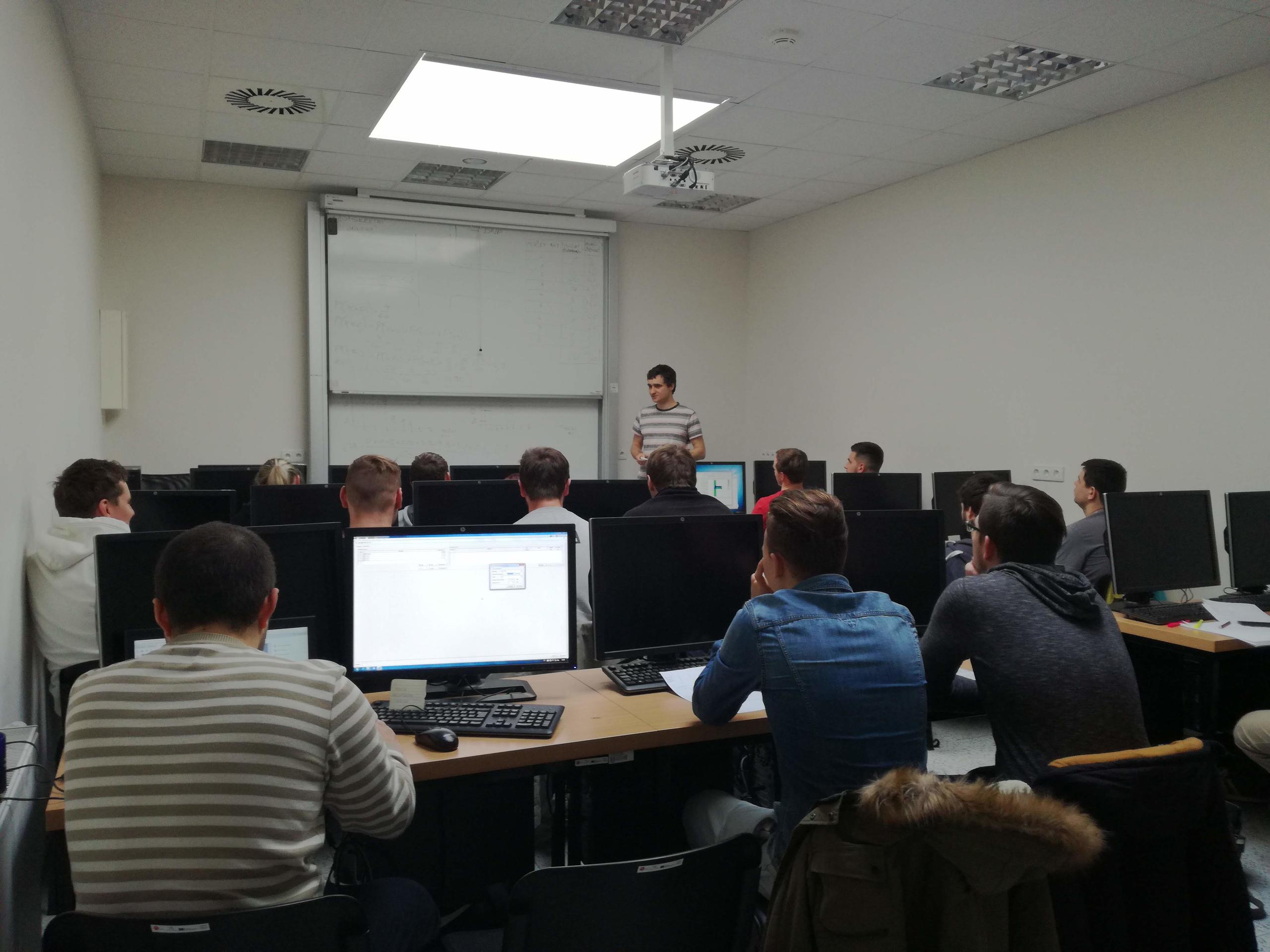 Dr. Řoutil is delivering a lecture in an IT classroom